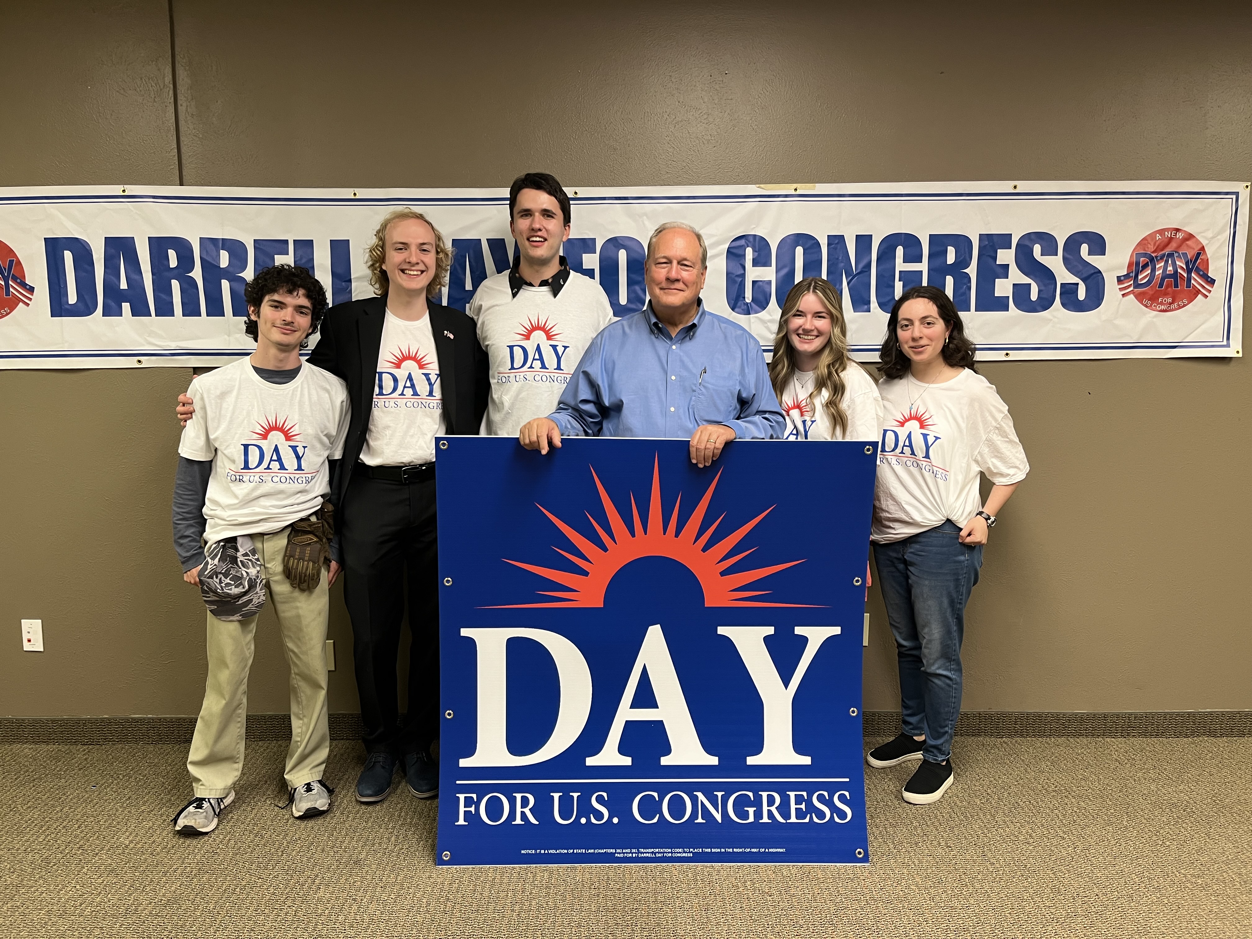 Darrell Day standing with campaign volunteers holding a ‘Day for U.S. Congress’ sign at a campaign event in Texas District 32.